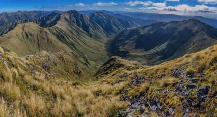 While it’s hard work along the ridge between Waingawa and Arete, the views are worth the effort. Being on some of the highest of the Tararuas’ tops, there are expansive vistas in every direction most of the time. It’s only when you get up close and personal with steep sections that they seem to disappear in favour of close-ups of the next tussock or rocky handhold. From Bannister there’s a clear view west over the Twins (1,466m and 1,440m) to Arete, Arete Bivy directly beneath and Lancaster a little further to the south. And east of Lancaster is Pinnacle Ridge, dropping steeply to Arete Forks, then leading away east around the ‘worst trail’ to Cow Creek.
Although I didn’t have to climb Arete in order to reach the bivy beneath – there’s a trail that traverses across beneath Arete, I did in order to honour my goal for the trip. By the time I’d had a photo-stop on top of Arete it was nearly 6pm, 12 hours on from when I set off from Kiriwhakapapa camp site that morning.