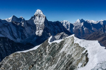 Nevertheless, now with crampons on and roped up, Kami led the way up into a world of tortured ice bulges, cliffs and crevasses for a hundred or so vertical metres. This flattened out into a fairly large shelf, at the far end of which was a two hundred metre headwall. The gradient was fifty degrees or so, with a fixed line still in place, left over from the season just been. We jumared up this, Kami ever attentive at each anchor point to make sure my jumar was safely transitioned. He was effectively babysitting me and, in my depleted state, I was happy to just go with the flow. This picture, looking along the summit ridge (away from the summit) to Ama Dablam.