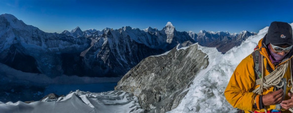 At last there was just enough light to carry on up, so we got out our crampons. As I fumbled with numbed fingers to get mine on one of the supposedly super tough plastic toe bindings suddenly shattered. I swore into the freezing wind. I couldn’t believe it but now, on reflection, I realise just how cold it was up there for that to happen. I’ve never had this problem, even in the depths of a winter blizzard, back in New Zealand.
Enter the super guide. Kami calmly swapped sets of crampons and improvised a way to effectively use my broken one. At 5,800m, suffering sleep deprivation, dehydration (our water supplies had frozen) and a hacking cough, I struggled with basic tasks. This just became more pronounced as we climbed higher. It was an enlightening experience, indicating to me that climbing Himalayan peaks might not be the best use of my climbing time in future. It’s a journey of suffering, where my technical performance became well below normal. While it was great to get so high, the process wasn’t very satisfying at all. This picture, Kami doing a bit of rope management with the summit ridge behind.