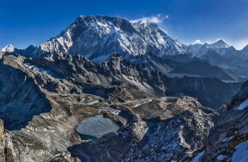 After our descent we had food and packed up camp. Chhongbi set off before us with a monster load, which I pondered more than once as we worked our own way down through huge rock formations and expansive, bare, golden hillsides, wearily reaching Chhukung 750 metres lower in mid-afternoon. This picture, Pokhalde summit view back down to our camp site. Kongma La is left, between shadow and light. Nuptse and Lhotse soar overhead and Makalu stands out on the right skyline.