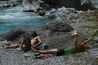 Christmas eve at Scone Hut in the Perth River, out the back of Harihari. In the three full days between the last shot and this one, we had traversed both Gardens, having committed in weather that turned out worse than forecast.   High on a Westland glacier in a breaking storm is no place to be, and it would give me some of the most terrifying moments of my life.  
I was getting hypothermia, losing my ability to behave rationally, just as they say you will.  We had to commit to a very dangerous descent of the rarely-trodden Eve’s Rib, and at the bottom our tent would be destroyed in a gale at 2 am.  In the next two days we would do battle a flooded Perth, often in Westland scrub and bush and, moving at 300 metres per hour max.