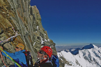 We clipped into a sturdy fixed wire cable and I tried to see where to next. Everywhere were what appeared to be sheer cliffs. Gary methodically worked on the rope, setting up the belay. Then off he went, out to the right, up an exposed crack system. He disappeared upward and the rope played out. Soon I got the signal to follow.