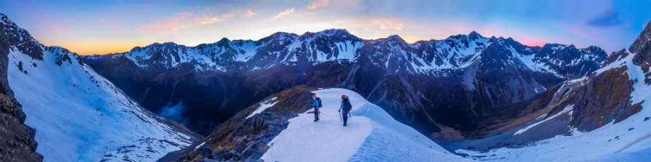As the others’ head torch beams grew smaller and smaller below us, Simon, Caro and I headed north and up to a broad shoulder at 1,880m. On the shoulder we enjoyed an expansive dawn view across to the St Arnaud Range and down the Travers Valley.
From the shoulder we lost about fifty metres as we sidled around to the next snow field, giving us access to the northeast ridge, just beneath a 2,127m highpoint. As we climbed, the gradient increased and the sun’s first rays began to make their softening and loosening effects felt. This image - The view east to the St Arnaud Range from the broad shoulder at 1,880m.