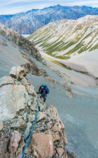 Following Piotr’s first pitch, James led on up a second steep section before we reached an exposed shoulder. Although we kept the rope on, this section was free-climbable. It led to a second near vertical section, requiring another rope length, before we reached some steep sloping scree on a ledge. Looming above was a huge wall and it wasn’t at all apparent where the southwest ridge route went next. In hindsight, we probably traversed too far left across the scree, ending up on the near vertical west face.