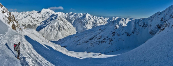 Next morning before dawn, Steve and I began our slog up to Temple Basin. It was chilly but a lovely clear morning.  Just enough clouds to catch the warm colours of the rising sun and, as we ascended, an ever improving view of Rolleston across the valley. Graeme had suggested that we keep an eye on Rolleston to see what its upper slopes looked like as the day wore on.
To begin with, Rolleston was a huge lump of ice cream, glowing orange and then transforming into vanilla. A lot of snow, that hopefully the sun would melt; and then the coming clear cold night would freeze nicely. So we thought at least.
This image - above the ski field and below Temple Col