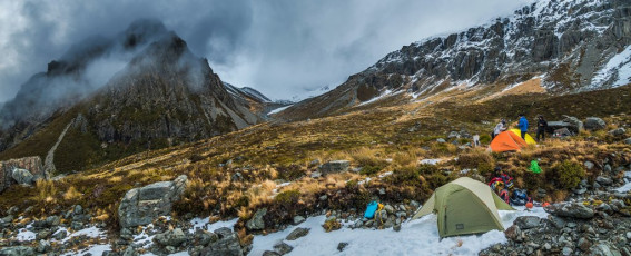 Unlike many these days, my pathway into climbing was hiking rather than rock climbing. I’m still more inclined to tackle a route that includes a summit if the going’s good, rather than focus primarily on technical climbing. But on this trip most of my companions owned many more cams, quick draws and ice screws than I. Our focus was the pursuit of vertical ice and I hoped to learn plenty from them.
The weather had been all over the place in the week leading up to our departure. The forecast was sufficiently bad just a day out to postpone. But then Piotr Nowak, our Christchurch based trip leader, called me on Thursday morning after the forecast did a miraculous U turn over night, explaining we were on again. Could I sort a flight?
This image - Our campsite at 1,150m, looking south to Mauka Atua, hidden in clouds.