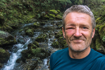 At one point the combination of slippery exposed rock and stinging nettles became impassable. We were forced to abandon the semblance of a trail in favour of a semi-vertical, moss covered boulder field. I took a tumble into a cluster of nettles and, just as I thought we’d dealt with the worst of it, I looked up directly into a small round hole with wasps coming in and out of it. Oh shit – things went a bit silly as I tried to get as far past the hole, as quickly as I could. Sting to the leg, sting to the head, many expletives and flapping of hands. Then, no more stings – thank goodness for that. Shaun and Darryn were also stung. At least the gradient soon eased off and we left the nettles behind. This image - a selfie taken that evening beside the upper section of Baton River, beside Flanagan's Hut - wasp impact evident.