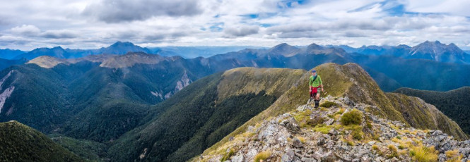 Next morning dawned calm with high cloud, perfect hiking conditions as we pushed on to Wangapeka Saddle at 1,010m. From there we all dropped our packs and clambered up a steep slope onto the tops beneath Nugget Knob, a 1,505m high point. The summit proved to be further than expected, but well worth the effort for the views and the enjoyable, rocky, knife edged ridge beneath the summit. After lunch back down at the saddle, we shouldered our packs and headed on upwards again to Biggs Tops at 1,300m. This image - Looking north from Nugget Knob, back along the approach ridge. Wangapeka saddle is in the dip left of centre, with the Biggs Tops and Mt Kendall beyond. Mt Patriarch is far right.