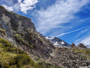 My understanding was that all I had to do was keep on the ridge. It did seem a bit odd though how poor the condition of the trail was getting. I could still see a trail, but disturbing cracks were beginning to appear in the dry, rocky earth. The further I descended, the more these cracks looked like small crevasses, until I reached a sudden end point where daylight shone through gaping holes. The rapid contraction of Ball Glacier had left huge exposed rock slopes behind, no longer supported by glacial ice. The land was literally falling apart. Yikes, time to backtrack.
I sweated my way back up the ridge and met Simon and Caro. We decided to drop straight off the ridge, down steep scrub and hope we weren’t bluffed. It was a good call. If we’d gone any sooner we would have been bluffed, but at that point we snuck down on to the flatter boulder and scrub field below. We’d all missed the new track, which drops off on the east side of the ridge at about 1,400m.
This image - Where the ridge ends in a fractured chaos of rock and earth.
