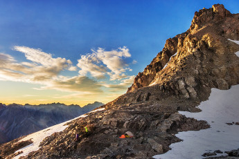 Our next surprise was the craggy high point looming to the south, directly above camp. The day dawned calm and clear and we felt no particular compunction to break camp. The crag looked suitably climbable, to the extent that it would’ve been rude not to. This image - At dawn, the camp site with Kaitiaki Peak above.