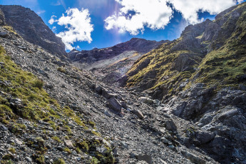 We wandered around scratching our heads for half an hour or so before spotting a solitary cairn, hidden in a sea of rock. The main problem was that, leading up out of the camping area, there are at least two viable looking chutes. Eventually we realised that it’s the most northern one we needed to ascend. This image - Looking up from about 1,300m towards the base of the snow chute, hidden above in this picture.