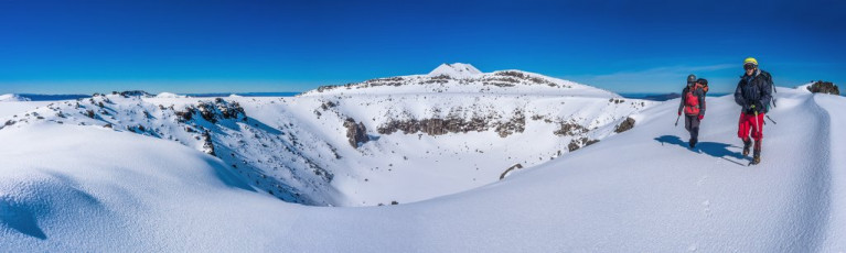 Camping up on top put us in position to enjoy what MetService had accurately predicted would be a primo, blue bird day in what really is a crater-pocked landscape. Our route skirted around North Crater, across a large flat plateau. From there we dropped 100 metres on what proved to be the steepest section of the day, requiring some front pointing, to the northern end of the main crossing trail above Ketetahi. This image - Making our way around North Crater, with Ngauruhoe's summit behind.