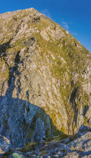 This image - Looking down from the east side of the notch, with the crux of the upper section of Mitre Peak stretching upwards on the far side.