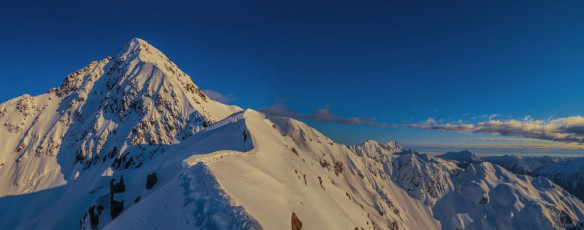 Just over three years before, another climbing buddy Steve Henderson and I, had set off before dawn up Otira Valley, plugging our own energy sapping steps. By the time we’d reached the big boulder near the top of Otira River, under a crystal clear blue sky, we’d reluctantly realised that our efforts were futile and to venture any further would be inviting burial beneath an avalanche. So now, as I climbed Rome Ridge, I said silent thankyous to the owners of the steps making it so much easier for us.
This image - At about 1,800m on Rome Ridge, on the narrow section before the notch.