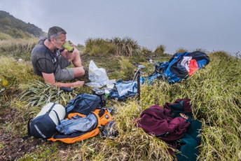 It had become cloudy on the tops, so I settled in for a long night in my bivy bag, perched on top of springy tussock. I hadn’t seen a soul all day, but when Hector’s summit cleared for moment in swirling cloud just on sunset, a tiny figure looked back at me from beside the memorial cross. During the night cloud continued to swirl. At times I got beautiful glimpses of the night sky, but I had no great expectations for the dawn.