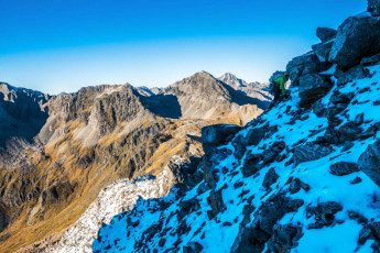 The condition on the slopes falling off the ridge wasn’t encouraging. Not enough snow to give any crampon and axe confidence – just slippery treachery. Often, where there was no snow, lay a coating of verglas.