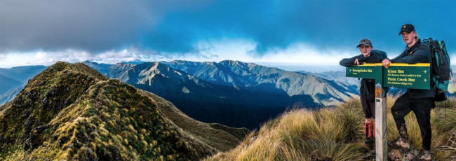 As it was, we were soon getting a selfie at the DOC sign on top of Maungahuka (1,330m). The clear weather slowly gave way to swirling cloud as we dropped down to Maungahuka Hut at dusk. I lingered for more photos, enjoying some beautiful cloud-at-sunset light. And life got even better after entering the hut. Four room temperature, i.e. chilled, bottles of Kiwi Larger sat gleaming appetizingly at me from the bench. Nec minute there were only three left and I felt considerably refreshed. The hut book revealed that two hunters had left them behind for all comers – legendary behaviour.