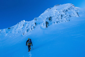 Finally underway to the base of the south west face, it was a joy listening to my crampons squeak up the frozen snow, as the rising sun painted our surroundings in violet, red, orange and yellow. And to my relief, the closer I got to the face, the more do-able it appeared. Our entry point to the face was an hourglass shaped ramp Piotr measured at 50 degrees.