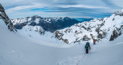 From the Col we got our first look down into the vast Caroline Glacier, fed from the icefall of the intimidating Caroline Face. Visibility was still quite good, although when looking east, the light was deceptively flat. We could still see most of the route down, then along an upward sloping shelf beneath the ANZAC Peaks, to a small dip at 2,180m. On the far side of this lay Boys Glacier. The unknown was what lay just over the convex bulge in front of us. The answer, unsurprisingly, was crevasses, but Simon was able to pick a way through these with only one ‘ah-oh, I’d better tread very softly because it’s black down there, please hold me’ moment.  This image - The view south over Cinerama Col (2,333m) to the Caroline Glacier.