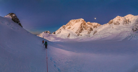 Sometimes the crux of the east ridge of Dixon is just getting across the schrund at the base of the steep chute giving access to the east ridge. Therefore we decided to get underway just a couple of hours before dawn so that, by the time we reached the schrund, it would be light. As it turned out, the dawn sky was crystal clear and a full moon illuminated the Plateau as well as any floodlights could. I did feel pangs of regret for not getting away earlier as we made slow progress plugging through very soft snow. Though the temperature had fallen well below zero during the night the snow was super-dry, unconsolidated powder. This image - At dawn on our approach to Mt Dixon, looking south to the ANZACs, Mounts Cook, Dampier, Vancouver, Silberhorn and Tasman.