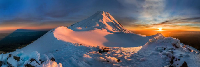 Looking north and east from the southern edge of Fantham's Peak to Mt Taranaki, at sunrise. The shadow of Mt Taranaki is far left.