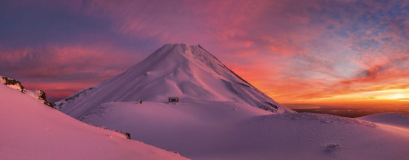 Perched at 1,950 metres, near the northern edge of Fantham’s Peak, it commands perhaps the best view anywhere of the top 600 metres of the mountain. This is particularly so at dawn on clear mornings when the sun, rising in the east, paints everything in view purple, then mauve, then deep red, fiery orange and finally golden yellow as the sun breaches the distant horizon, taking its place next to Tongariro, Ngauruhoe and Ruapehu.